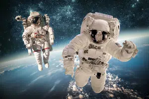 Two astronauts on a space walk above the earth